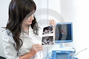 Beautiful female doctor sitting in her office near ultrasound sc
