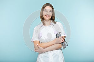 Beautiful female doctor with a stethoscope with crossed arms on a blue background. healthcare concept.