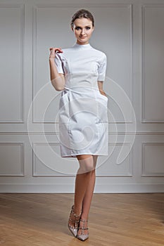 Beautiful doctor in white clothes. Portrait of attractive medic in white robe