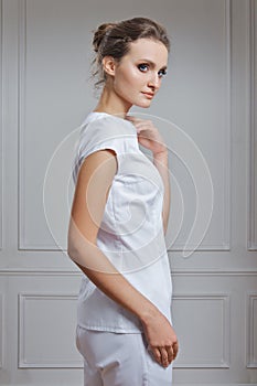 Beautiful female doctor in white clothes. Portrait of attractive medic in white robe