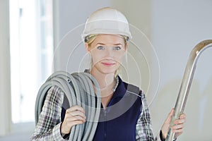 Beautiful female electrician holding cable