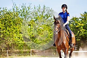 Beautiful female equestrian sits astride a horse