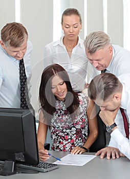 Beautiful female executive pointing at laptop scre