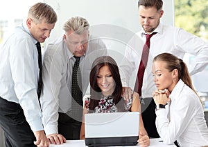 Beautiful female executive pointing at laptop scre