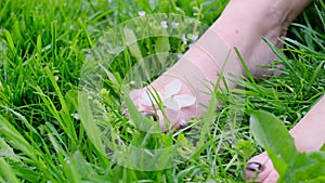 beautiful female feet barefoot on green grass