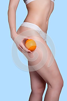 Beautiful female figure with an orange holds near the