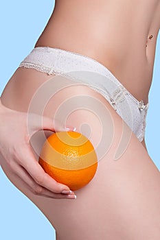 Beautiful female figure with an orange holds near the