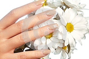 Beautiful female fingers with pastel pink manicure touching spring flowers. Care about female hands, healthy soft skin. Spa ,