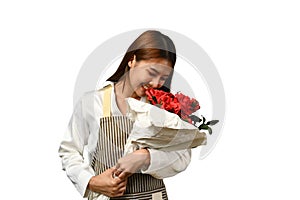 Beautiful female florist smelling red roses with closed eyes isolated on white background