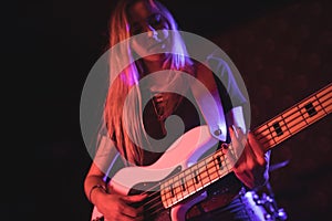 Beautiful female guitarist performing in nightclub