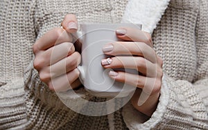 Beautiful female hand with beige nail design.
