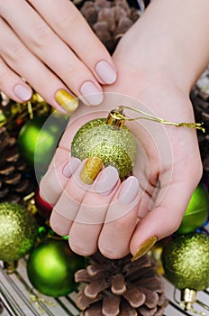 Beautiful female hand with beige nail design. Christmas manicure.