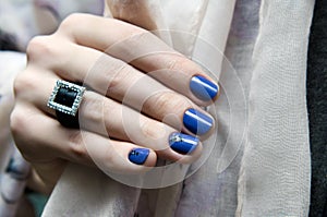 Beautiful female hand with blue nail design.