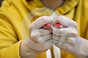 Beautiful female hand with elegant manicure shows a sign of a fig, blue background. body language. Finger Hand Sign  on