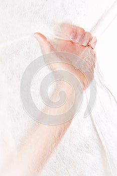 Beautiful female hand grabbing white fabric