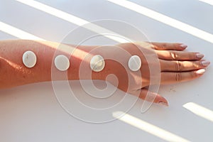 Beautiful female hand with massage stones with long shadow. Concept of spa, relaxation, and meditation