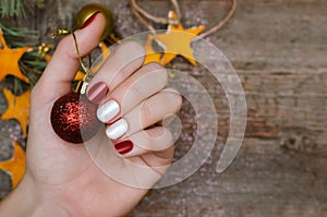 Beautiful female hand with red and white nail design. Christmas manicure.