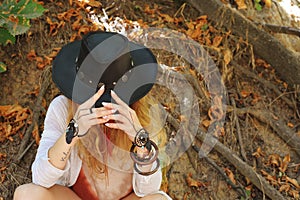 Beautiful female hands with boho chic dreamcatcher bracelets and black leather hat