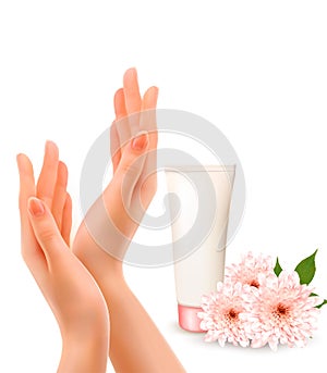 Beautiful female hands with a cream and flowers.