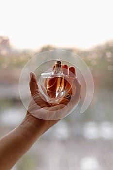 Beautiful female hands, a girl holding a bottle of perfume in her hands