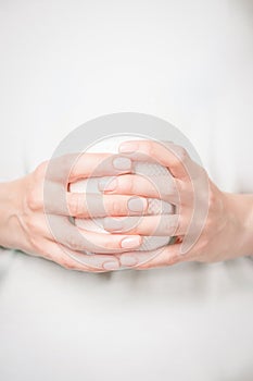 Beautiful female hands holding white cup. Manicure with natural color nail polish. Copy space