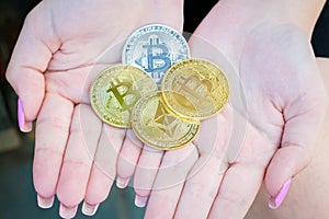 Beautiful female hands with manicure holding a souvenir coins of Bitcoin cryptocurrency. Modern digital crypto gold, e-commerce,