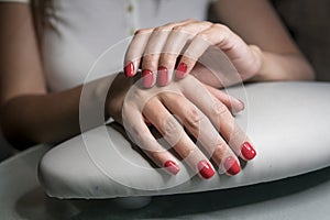 Beautiful female hands with red nails in beauty nail salon. Beautiful female nails and manicure.