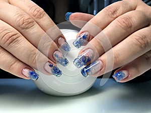 Beautiful female hands with a transparent manicure and fashionable design.