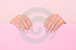 Beautiful female hands with white manicure, hearts design