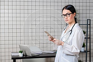 Beautiful female healthcare worker using tablet computer in hospital