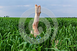 Beautiful female legs sticking out of the grass