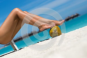 Beautiful female legs in the tropical beach conceptual image of