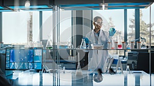 Beautiful Female Medical Scientist Wearing White Coat and Safety Glasses uses Micropipette while E