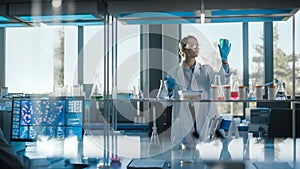 Beautiful Female Medical Scientist Wearing White Coat and Safety Glasses uses Micropipette while E