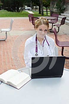 Beautiful female medical student wearing whitecoat