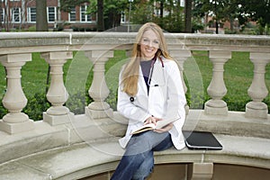 Beautiful female medical student wearing whitecoat