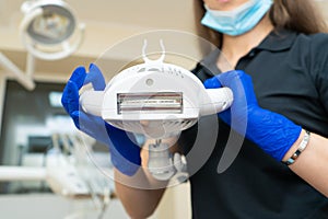 Beautiful female model advertising teeth whitening in a dental clinic with professional equipment