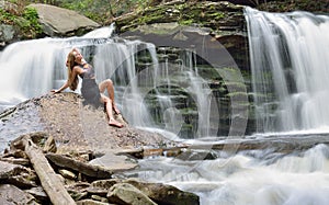Beautiful female model posing in front of waterfall