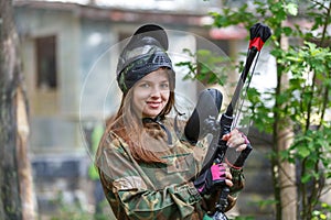 Beautiful female model posing in paintball ammunition outdoors