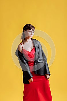 Beautiful female model in a red dress yellow background