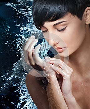 Beautiful female model washing hands in stream of water