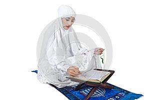 Beautiful female muslim read Kuran - isolated photo