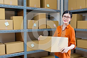 Beautiful female office worker holding big box