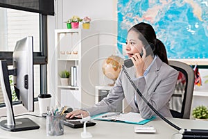 Beautiful female office worker looking at computer