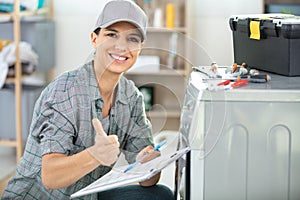 beautiful female plumber repairing washing machine