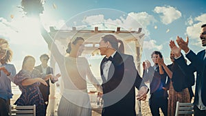 Beautiful Female Queer Couple Walking Up the Aisle at Outdoors Wedding Ceremony Near Sea. Two