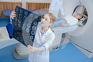 Beautiful female radiologist looking at the MRI scan images