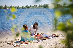 Beautiful female receiving energy sound massage with singing bowls and body massage on a river bank