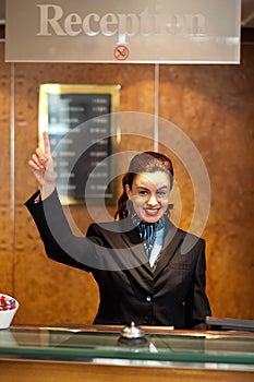 Beautiful female receptionist indicating upwards