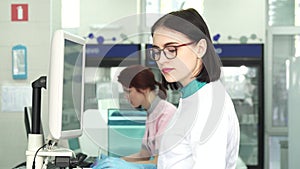 Beautiful female scientist working on a computer at the lab